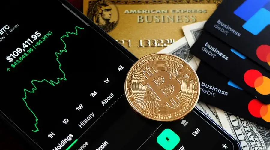 Bitcoin and credit cards on smartphone for digital trading representation.