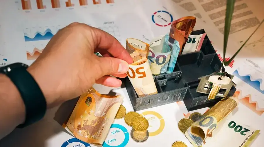 Euro bills and coins with financial charts showcasing budgeting and investment planning.