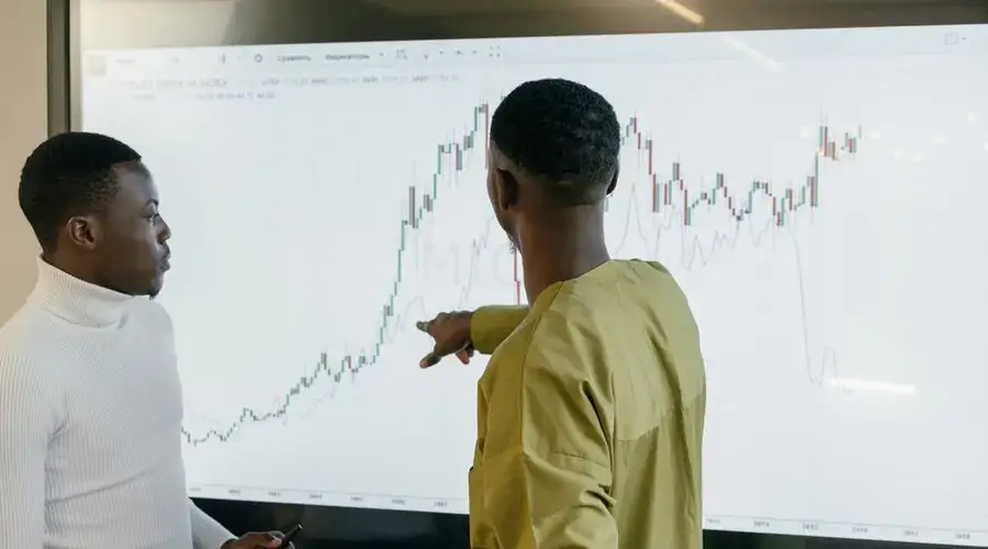 Two professionals discussing financial trends on a graph at the office.