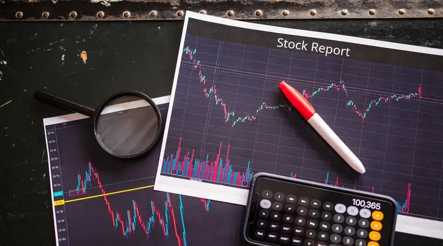Stock report with charts, calculator, and magnifying glass for financial analysis.