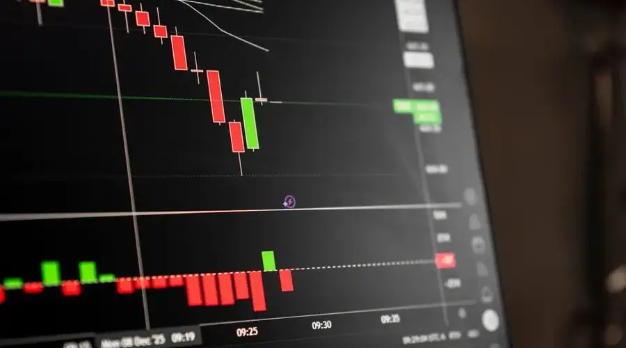 A close-up of a digital screen showing stock market candlestick chart data.