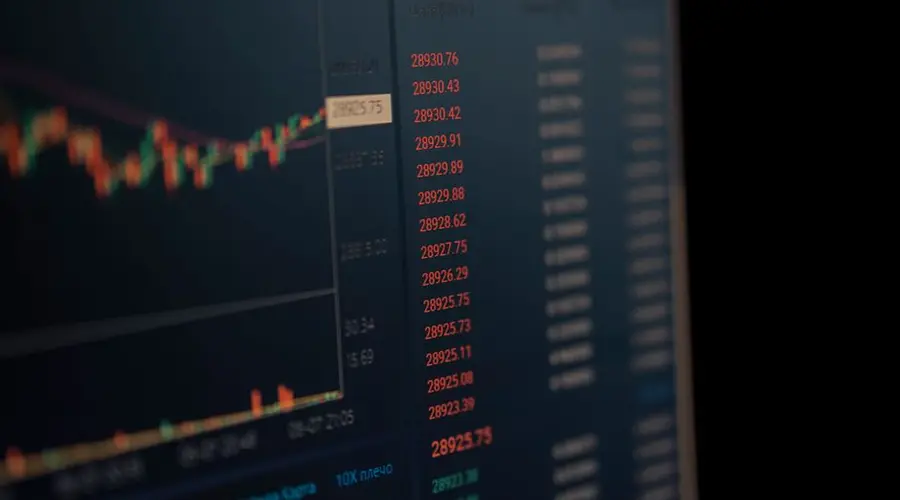 Close-up of a computer screen showing dynamic financial market data and charts, indicating real-time trading updates.