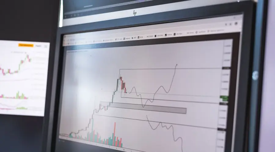 Close-up of stock market analysis charts on a monitor, showcasing market trends.