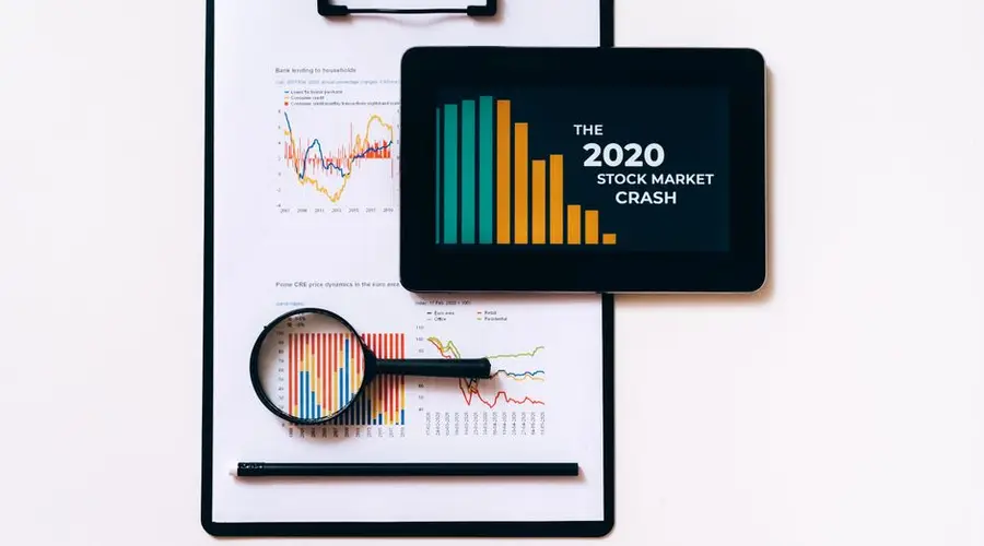 Tablet and clipboard with charts illustrating the 2020 stock market crash.