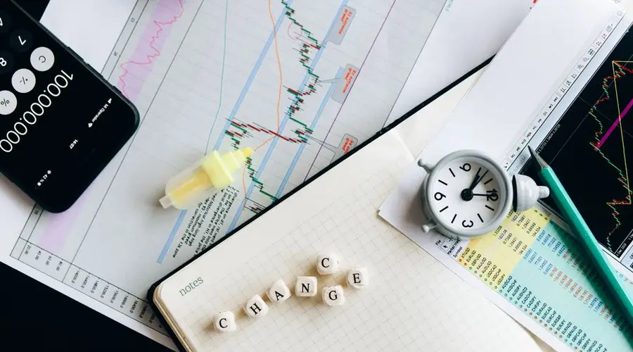 Top view of financial documents with charts, calculator, clock, and the word 'Change' in focus.
