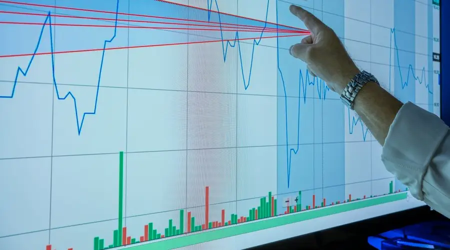 Closeup of hand analyzing financial graph on a digital screen for market trends and investment insights.