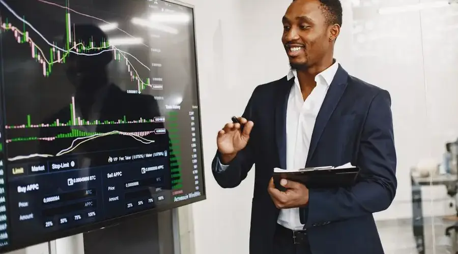 Professional man presenting financial data on a digital screen in modern office.