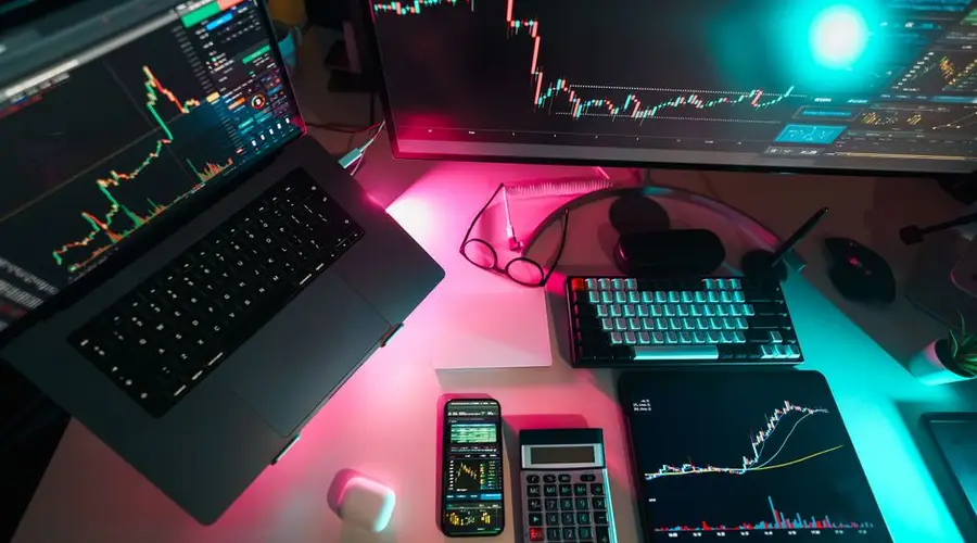 High-tech trading setup featuring digital charts on multiple devices, ideal for finance professionals.