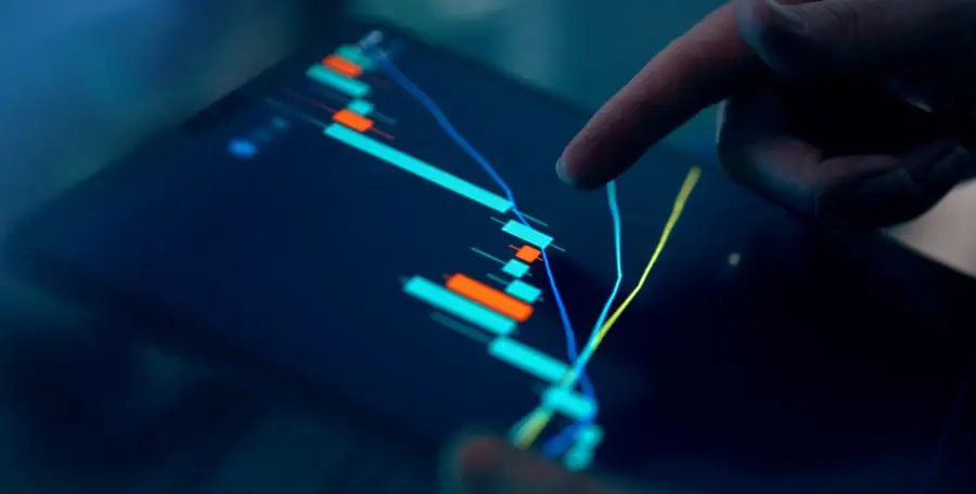 Close-up of a finger interacting with a digital chart on a tablet, depicting financial data and analysis.