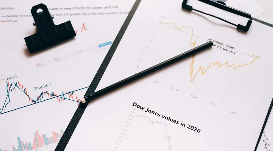 Clipboard with stock market charts and graphs representing financial data analysis.