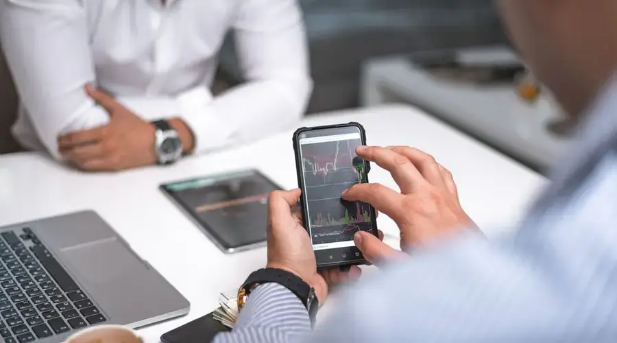 Business professionals using smartphone for data analysis in a modern office setting.