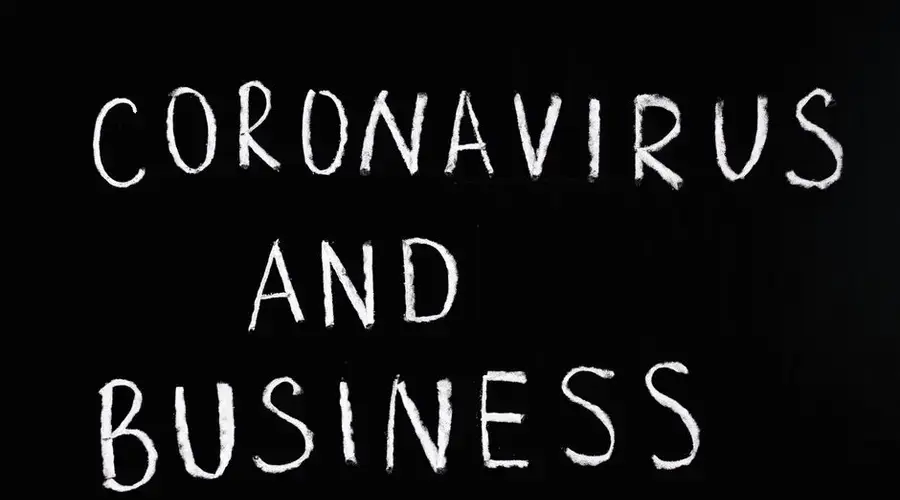 Chalkboard with 'Coronavirus and Business' written on it, illustrating COVID-19 impact.