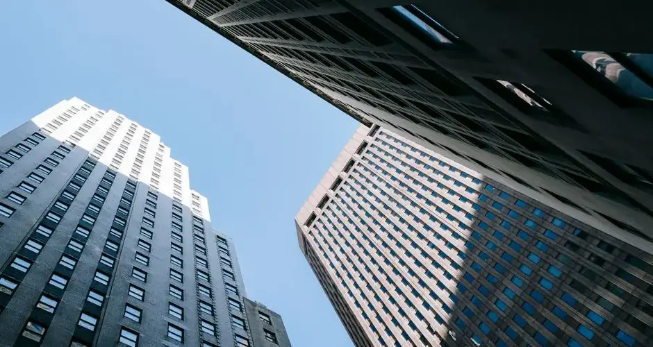 From below of contemporary high multistory office skyscrapers located in downtown against blue sky