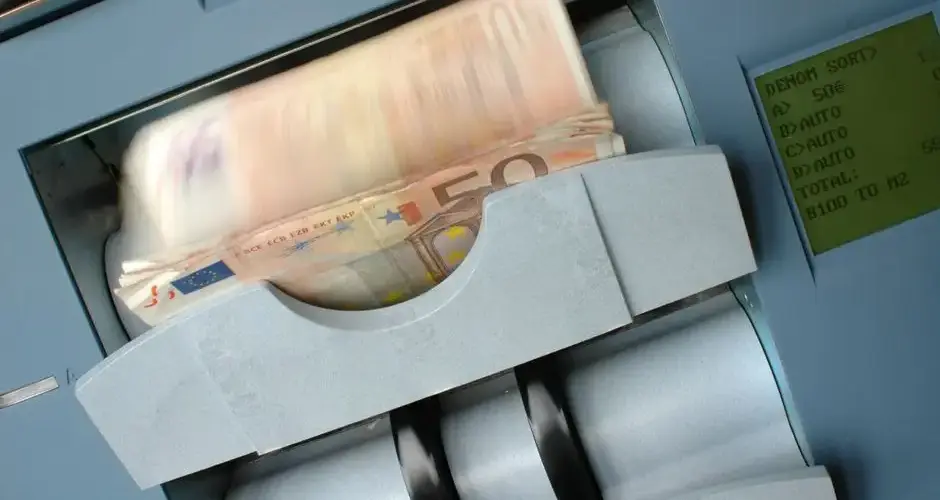 50 Euro banknotes being processed in a high-speed counting machine, showcasing technology and finance in action.