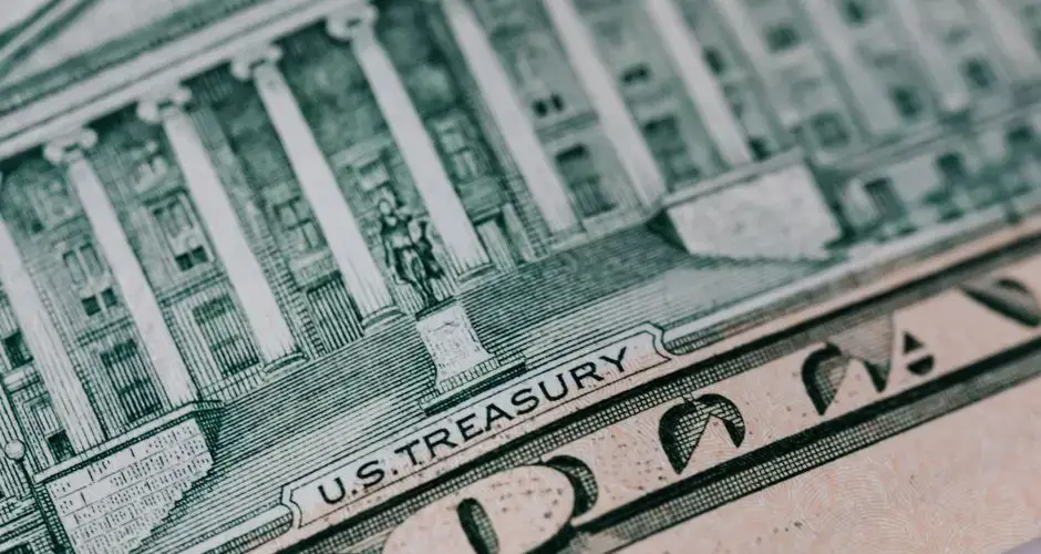 From above ten dollar banknote with inscription and United States treasury building placed on table