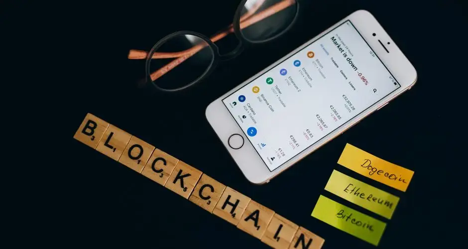 Smartphone displaying cryptocurrency market data alongside blockchain concept elements.