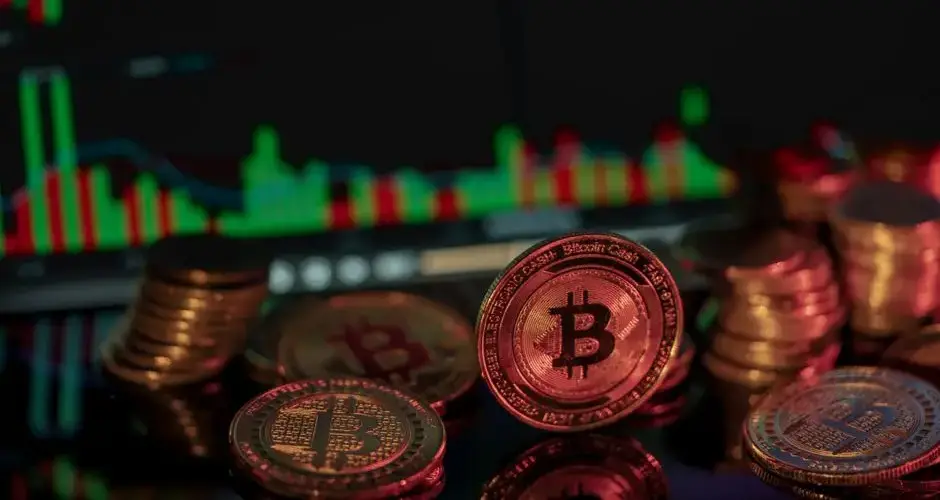 Bitcoin coins in front of a financial market chart, illustrating digital investment trends.