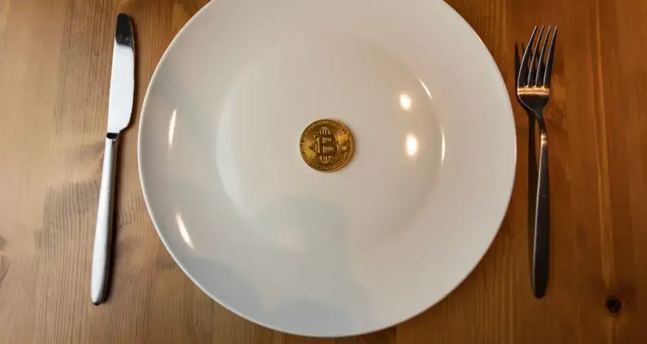 A conceptual image of a bitcoin placed on a dinner plate symbolizing the digital economy.