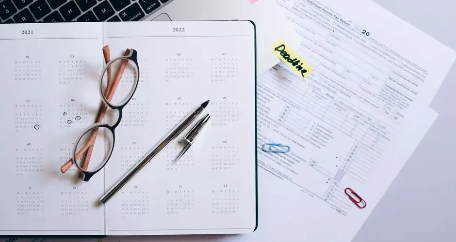 Organized workspace featuring a calendar, tax documents, and planner essentials.