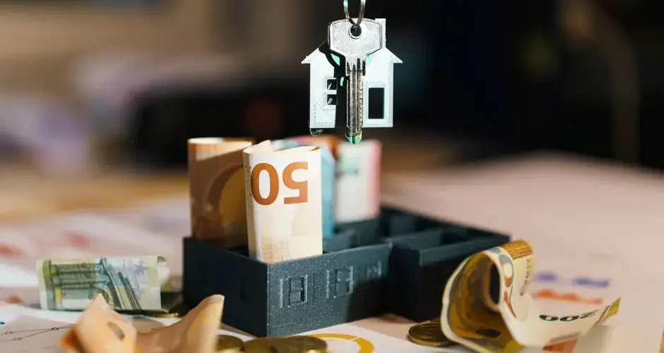 House key over Euro banknotes symbolizes real estate investment and financial planning.