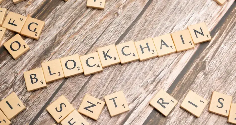 Wooden letter tiles form the word 'blockchain' arranged on a rustic wood background.