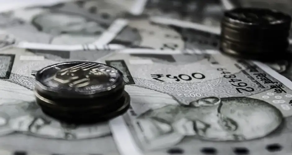 A detailed close-up of Indian currency notes and coins, highlighting financial themes.