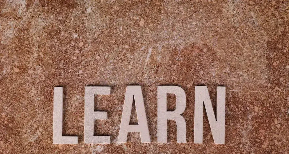 Wooden letters spelling 'Learn' on a textured marble surface, symbolizing education and growth.