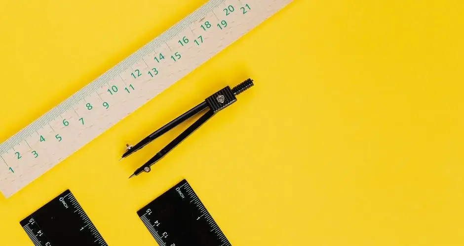 Vibrant still life of compass and rulers on a yellow background.