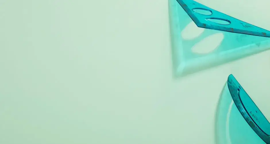 Abstract view of blue transparent set squares on a mint background.