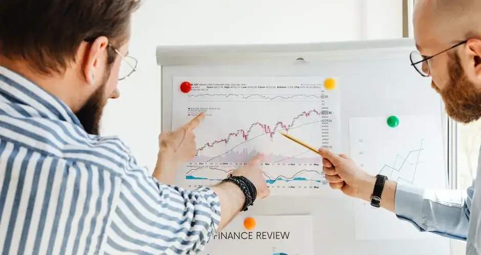 Two business professionals analyzing financial charts during a daytime meeting.