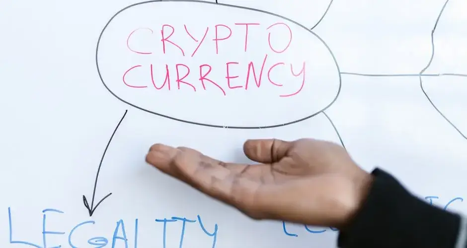 Close-up of a hand gesturing at a cryptocurrency diagram on a whiteboard, highlighting crypto concepts.