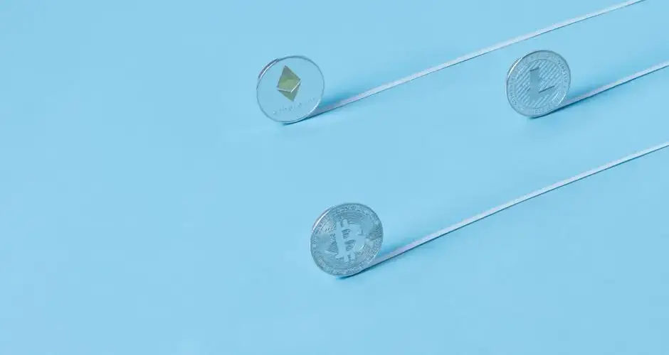 Minimalist image of Bitcoin, Ethereum, and Litecoin coins on a baby blue background.
