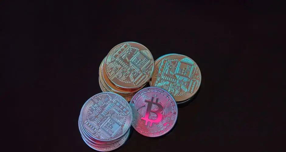 A detailed image showcasing a stack of Bitcoin cryptocurrency coins on a black background.