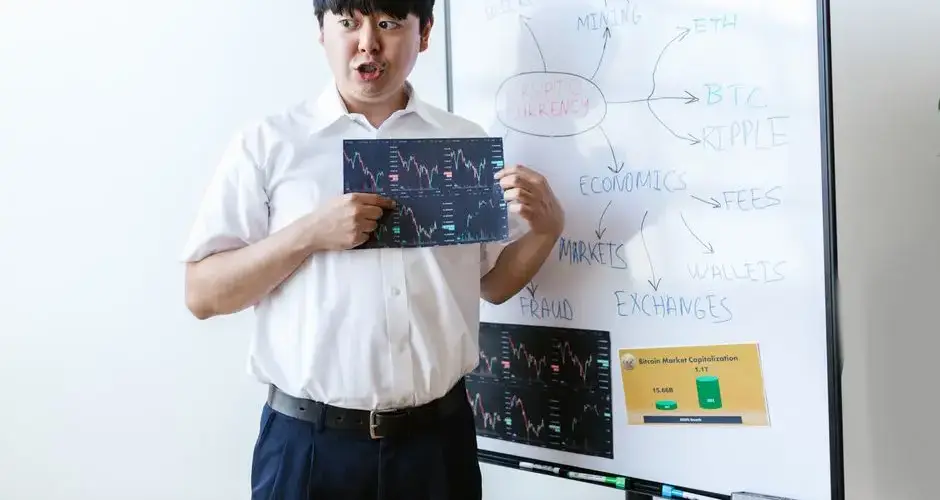 A man presenting cryptocurrency concepts on a whiteboard with charts and graphs.