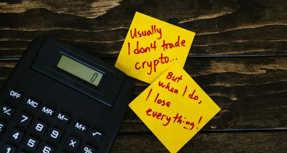 Funny sticky notes about cryptocurrency trading with calculator on wooden table.