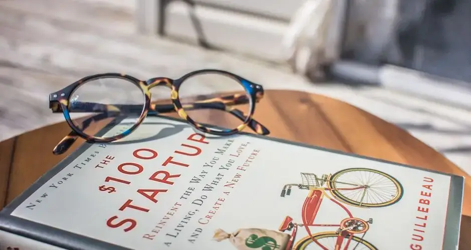 Close-up of a book and eyeglasses on a table, perfect for study or leisure reading.