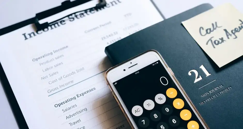 Close-up of income statement, calculator, and planner for financial planning.