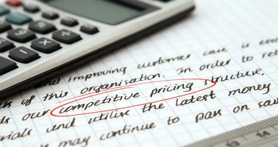 Focused image of handwritten business notes with calculator emphasizing pricing strategy.