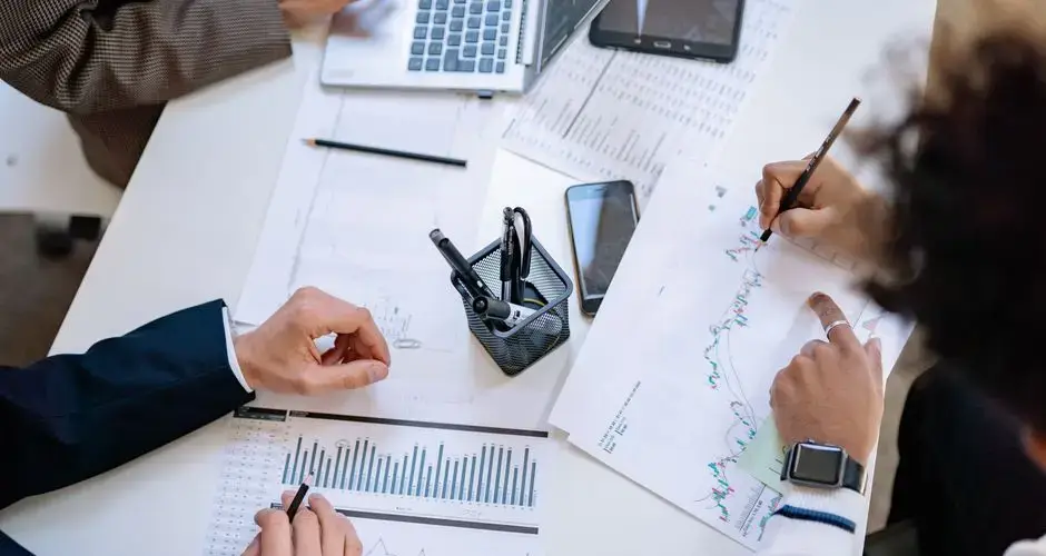 Business team analyzing financial charts and graphs during a collaborative meeting.