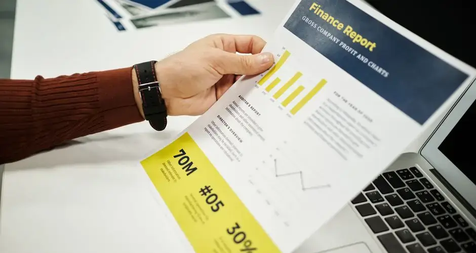 Person analyzing finance report with graphs at desk, ideal for business concepts.