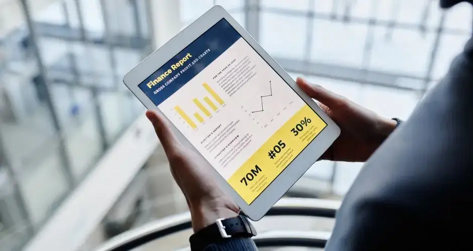 Businessman reviewing financial statistics on a tablet indoors.