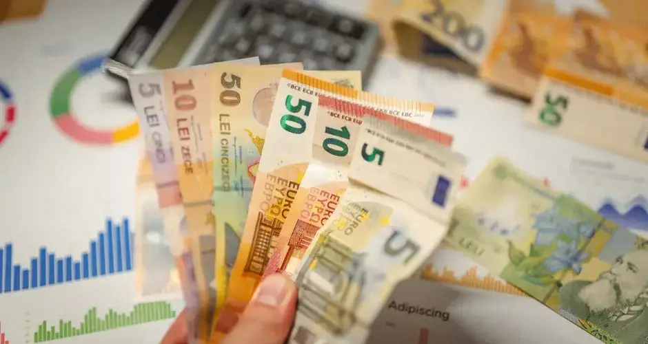 Close-up of currency notes with financial graphs and a calculator.