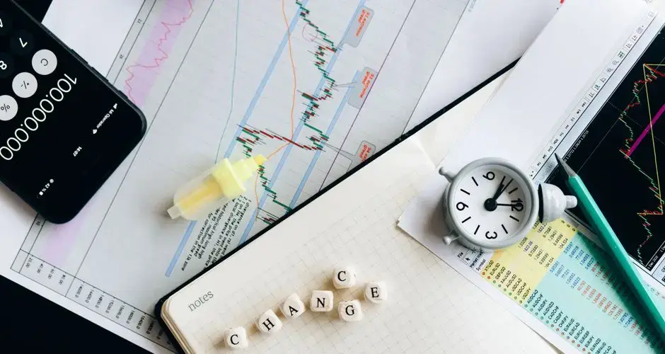 Top view of financial documents with charts, calculator, clock, and the word 'Change' in focus.