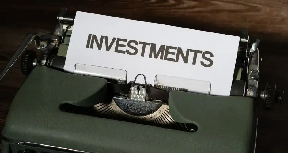 Close-up of a vintage typewriter with a paper labeled 'INVESTMENTS'.