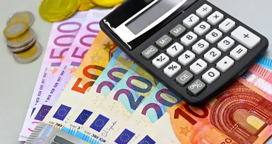 Image of euro banknotes, coins, and a calculator for financial planning. Perfect for finance themes.