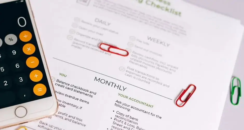 Image of a checklist and calculator for managing small business accounting tasks efficiently.