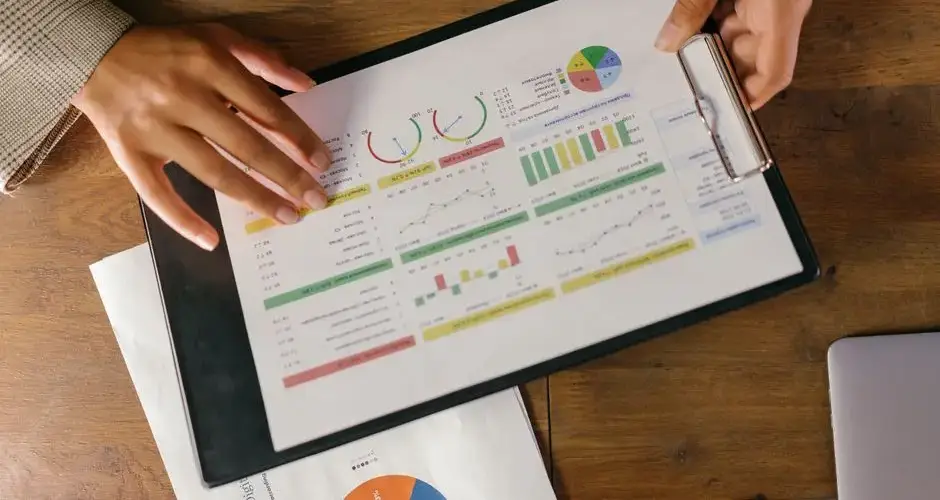 Top view of hands holding a financial report with colorful graphs and charts, ideal for business presentations.