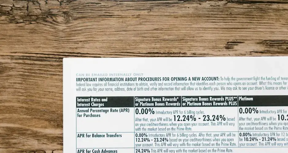 A detailed financial document listing interest rates on a textured wooden table.