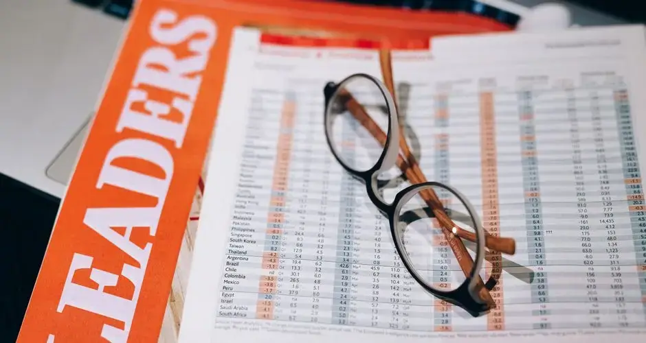 Close-up of financial documents with eyeglasses, depicting data analysis and business insights.