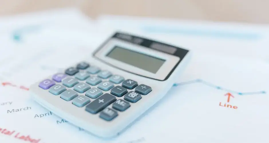 Close-up of a calculator on financial documents with graphs and analysis papers.